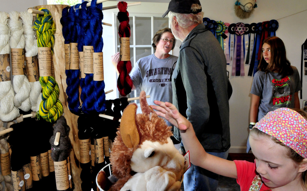 Jill McElderry-Maxwell speaks with William Reid inside her shop Sunday at the Bag End Suri Alpacas of Maine farm in Pittsfield during Maine Open Farm Day.