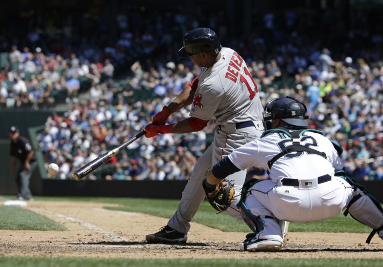 Rafael Devers hits a single in the seventh inning Wednesday at Seattle. Devers homered earlier in the game for his first major league hit.