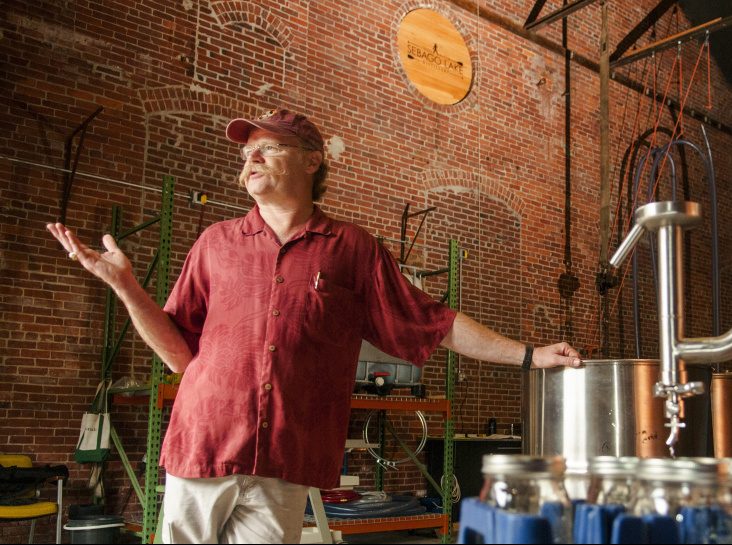 Standing beside the still, master distiller Dan Davis talks about the rum-making process Thursday during a tour of Sebago Lake Distillery.