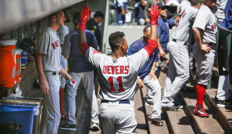 Boston third baseman Rafael Devers is jokingly ignored by teammates in the dugout after hitting his first career home run during the third inning against Seattle. Devers is the youngest player in the major leagues by 73 days.
