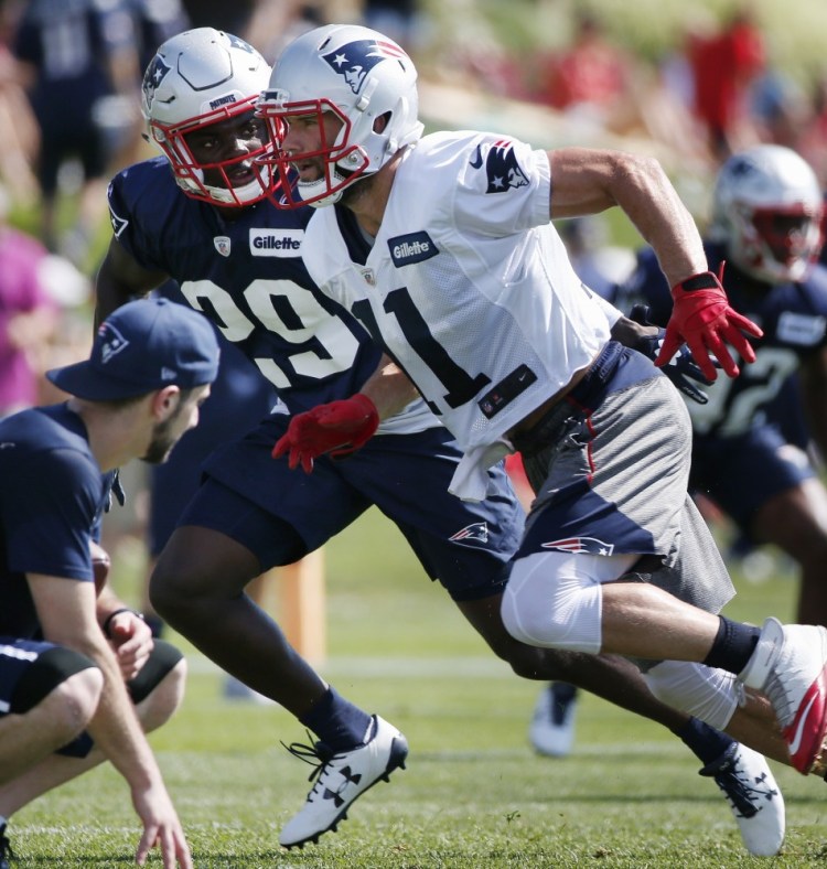 Patriots wide receiver Julian Edelman, right, runs a drill with defensive back D.J. Killings during training camp on Friday. Edelman is one of the veterans of what's become a deep position for New England.
