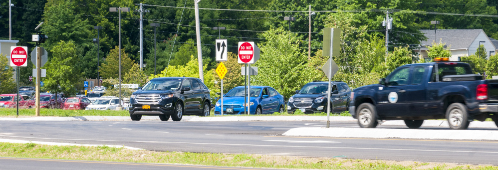 A line-up of cars, left, waits to turn left off Main Street and onto U.S. Route 202 on Friday in Winthrop. The turning traffic has stop signs, but the highway traffic does not.