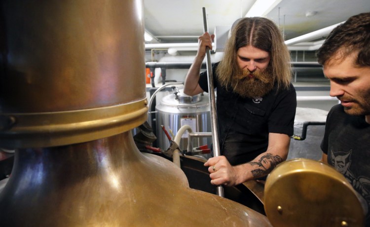 Sturlaugur Bjornsson, left, and Greg Abbot mix malt Thursday at Liquid Riot on Commercial Street for a small-batch beer. Bjornsson is brew master at Borg Brugghus – an unorthodox brewery in Iceland – while Abbot is head brewer at Liquid Riot.