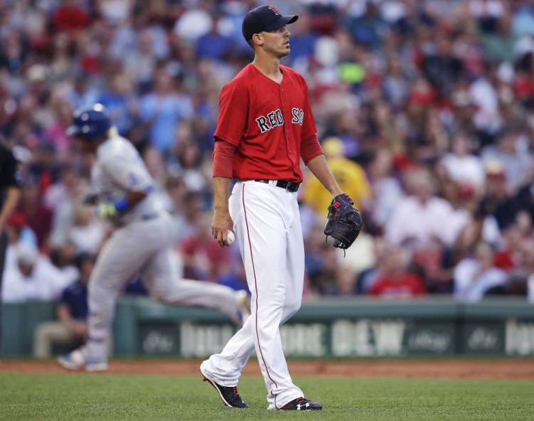 Red Sox starter Rick Porcello walks away from the mound with a fresh baseball as Kansas City's Salvador Perez rounds the bases after a solo home run in the second inning Friday night at Fenway Park.