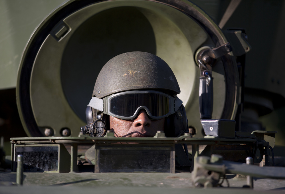 A Navy soldier patrols in an armored vehicle near Santos Dumont Airport, one of the quieter areas in Rio de Janeiro, Brazil, on Friday.