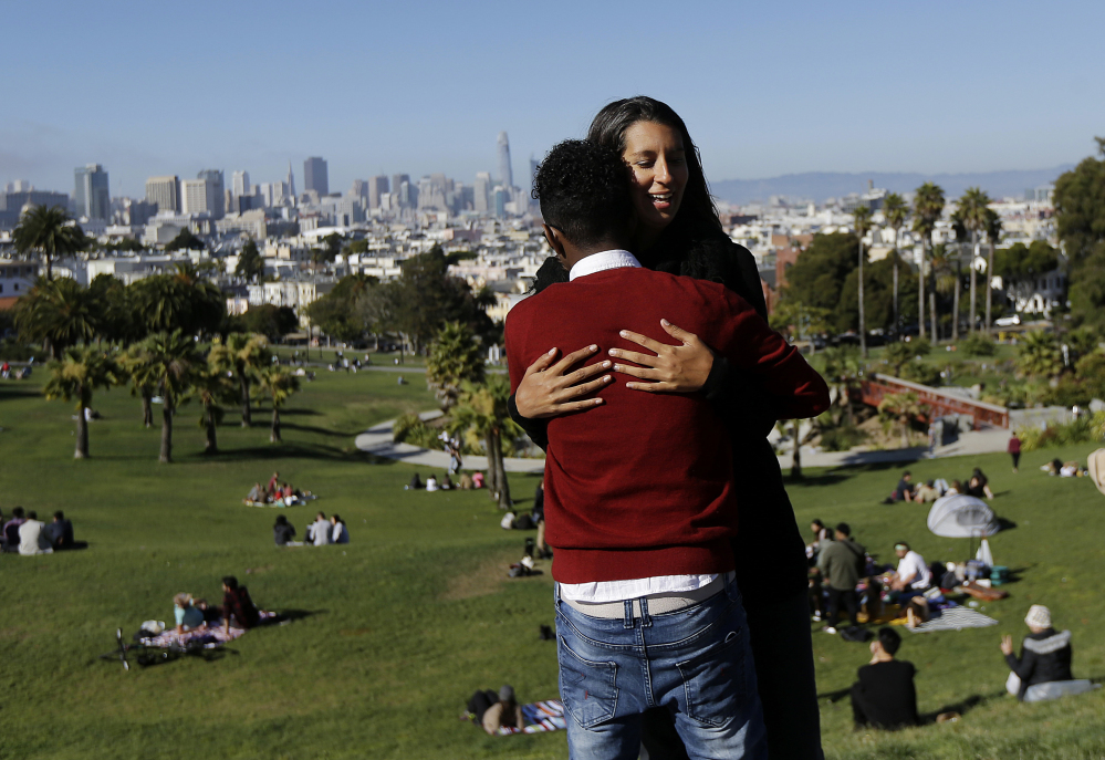 Julie Rajagopal hugs her 16-year-old foster child from Eritrea after posing for photos at Dolores Park in San Francisco. 