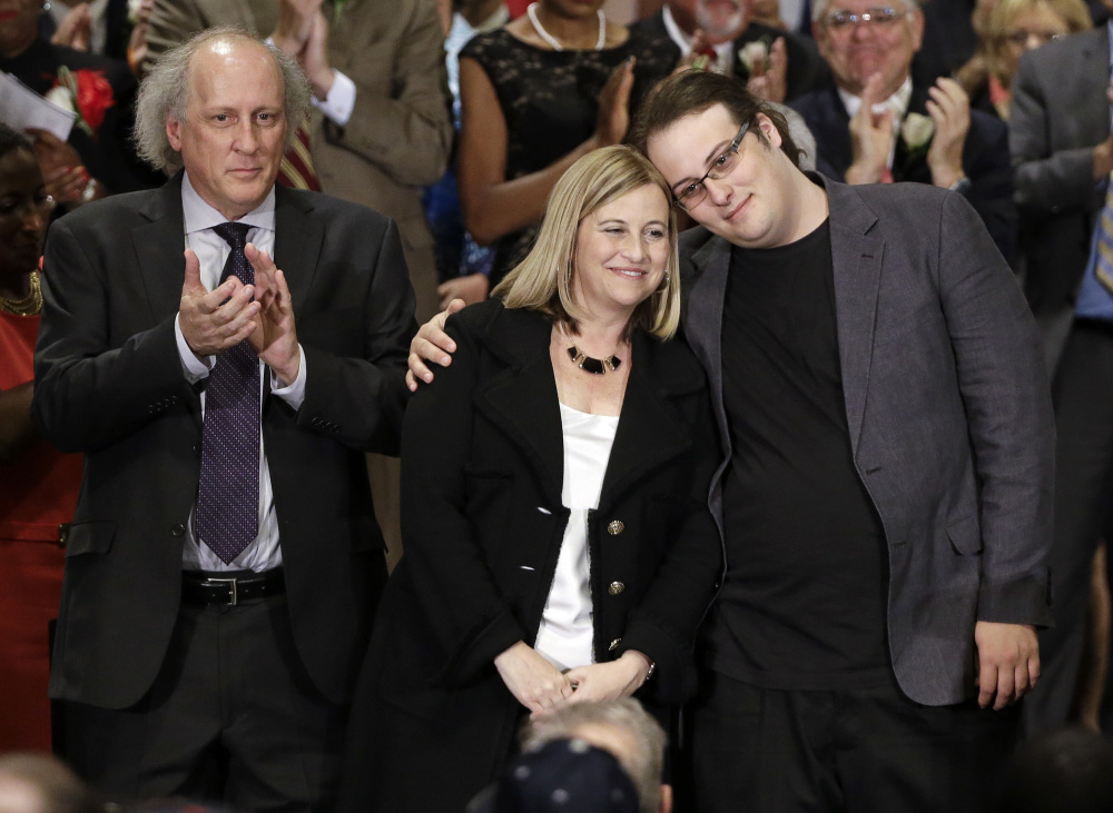 Nashville Mayor Megan Barry is hugged by her son, Max, as her husband, Bruce, left, applauds after she was sworn into office in 2015.
