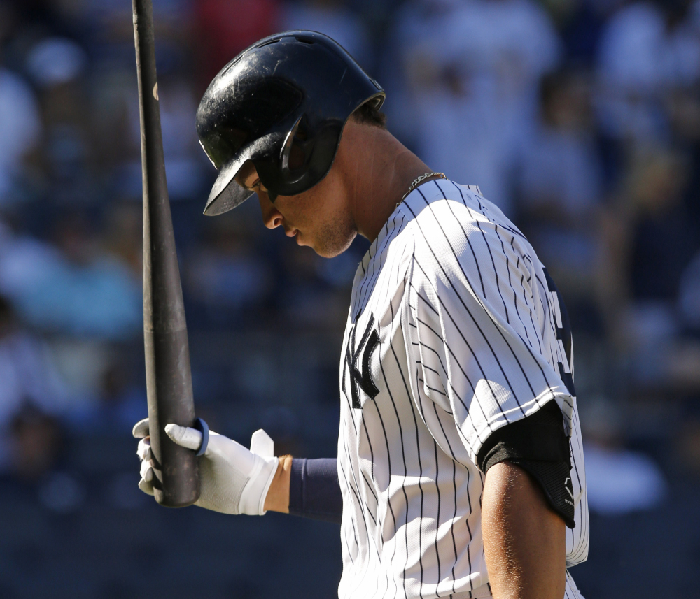 The Yankees' Aaron Judge hangs his head Sunday after fouling out to first with two runners on base in the ninth inning of New York's 5-3 loss to the Rays.