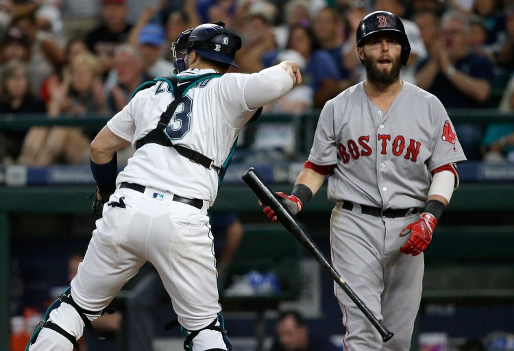 Boston's Dustin Pedroia, right, reacts to striking out swinging as Seattle Mariners catcher Mike Zunino returns the ball during the sixth inning Monday.