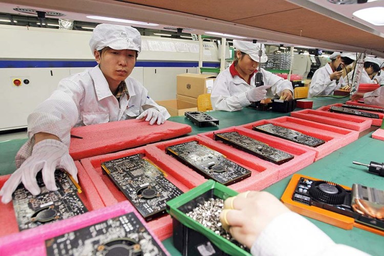 staff members work on the production line at the Foxconn complex in the southern Chinese city of Shenzhen.