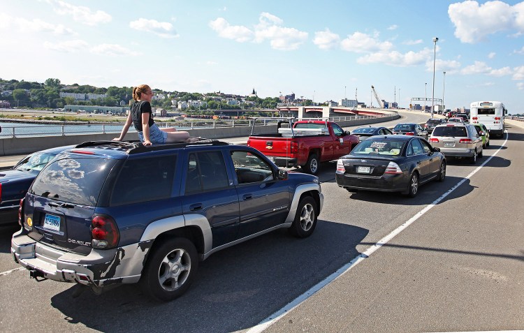 Kris English takes in the view from atop her car as motorists were stranded and rerouted when the arms on the Casco Bay Bridge were stuck. 