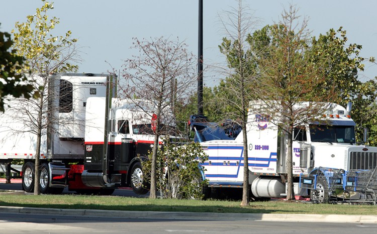 Police prepare to tow a tractor-trailer Sunday in which 10 people believed to be illegal immigrants being smuggled into the United States were found dead.  