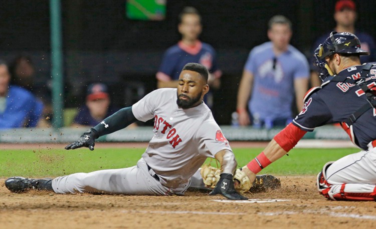 Jackie Bradley Jr. slides safely into home plate as Cleveland Indians catcher Yan Gomes is late on the tag in the seventh inning of Tuesday's game. He sprained his thumb during the slide.