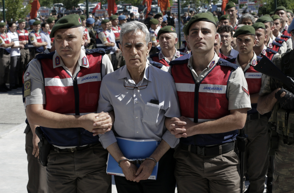 Akin Ozturk, Turkey's former Air Force commander, and dozens of the other 500 coup suspects are escorted by paramilitary police to a courthouse in Ankara on Monday.
ed Press/Burhan Ozbilici