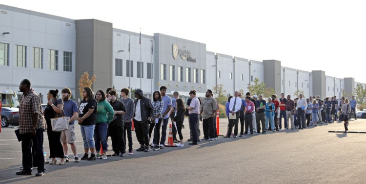 Applicants wait in line to enter a job fair at an Amazon fulfillment center, in Kent, Washington on Wednesday.. Amazon planned to make thousands of job offers on the spot.