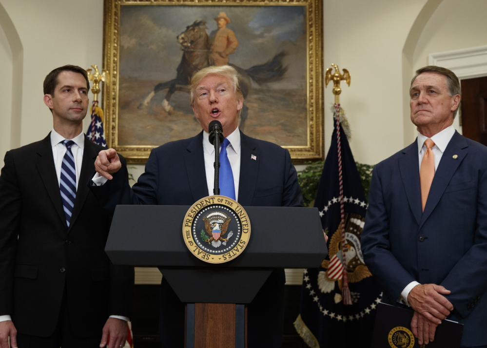 At the White House on Wednesday, President Trump talks about legislation sponsored by Sen. Tom Cotton, R-Ark., left, and Sen. David Perdue, R-Ga., to reduce legal immigration.