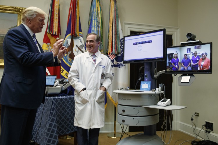 Veterans Affairs Secretary David Shulkin watches as President Trump talks with a patient during a Veterans Affairs Department "telehealth" event on Thursday n the Roosevelt Room of the White House in Washington.