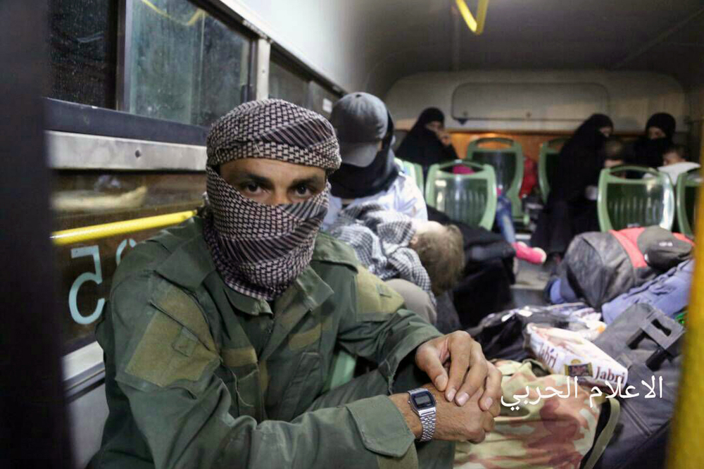 An al Qaida-linked militant sits in a bus after being evacuated Thursday from northeast Lebanon, part of a swap in which Syrian rebels would release political prisoners.