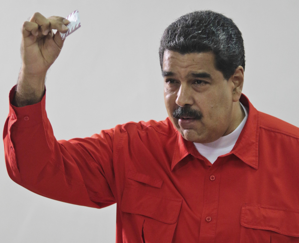 Venezuelan President Nicolas Maduro shows his ballot after casting a vote for a constitutional assembly.