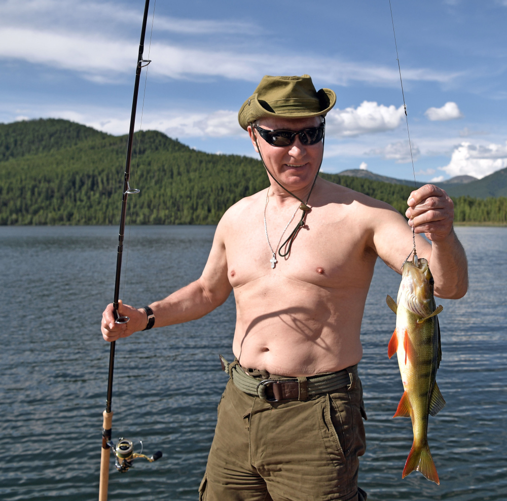 Russian President Vladimir Putin holds a fish he caught during a mini-break in the Siberian mountains this week. "It's a good catch," he beamed. 