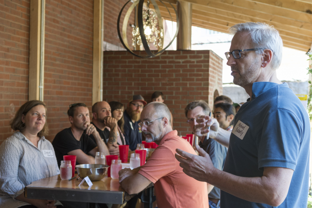 Michael Kalanty, author and sensory scientist, introduces himself to the blind taste test participants Wednesday at the Somerset Grist Mill in Skowhegan.