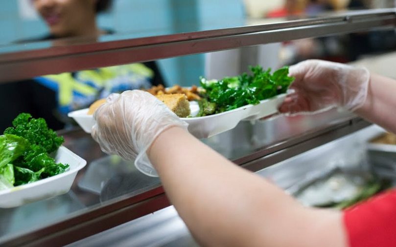 Food service staff at a Delaware high school serve a locally sourced lunch, including kale, in 2015. Only about one percent of the USDA's $19 billion school nutrition budget goes toward introducing fresh produce.