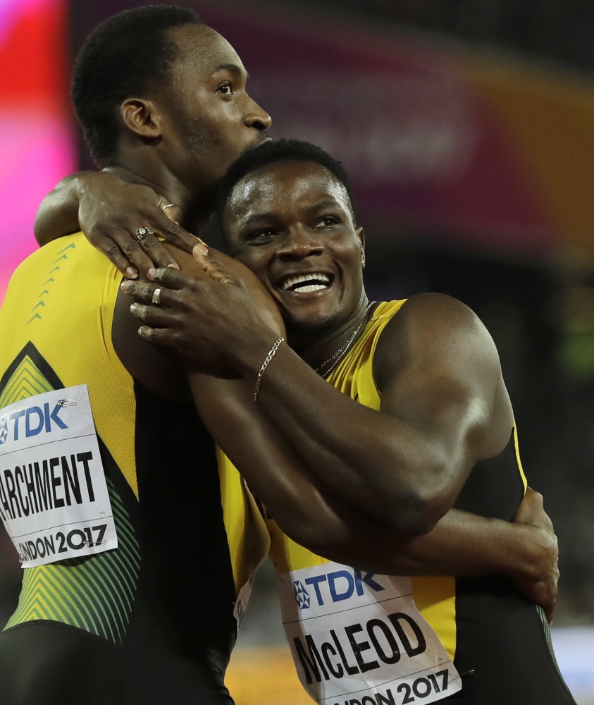 Jamaica's Omar Mcleod celebrates with Jamaica's Hansle Parchmentas after his gold medal performance.