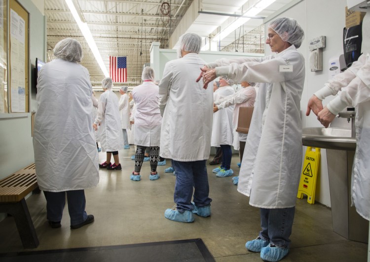 Employees do injury-prevention stretching exercises before their shift at Puritan Medical Products Co. LLC. Puritan and its sister company, with 475 workers, have kept health care premiums low by paying medical claims rather than using a third-party insurer.