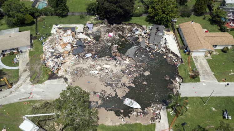 A 260-foot-wide sinkhole, which opened July 14 and swallowed two homes, is shown Friday in Land O' Lakes, Fla. State officials say that more homes could be condemned.