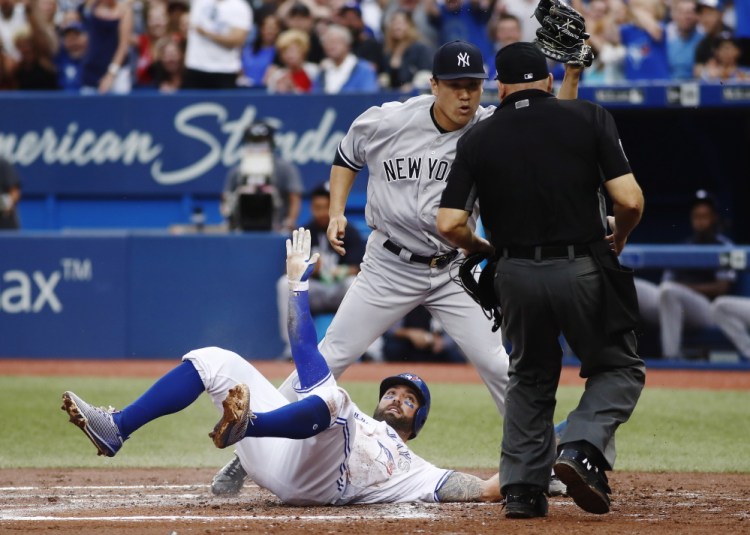 Kevin Pillar of the Toronto Blue Jays is out at the plate Wednesday night, tagged by pitcher Masahiro Tanaka of the New York Yankees after being caught in a rundown.