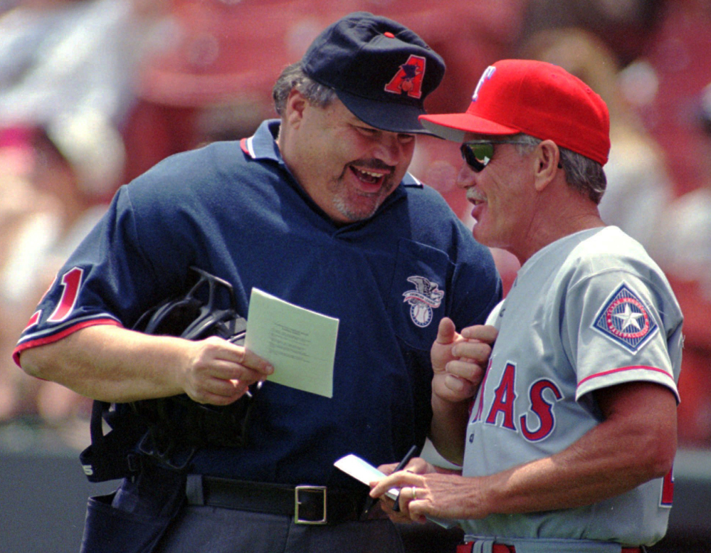 Umpire Ken Kaiser, left, shares a laugh with Texas Rangers Manager Johnny Oates before a game in 1997. Kaiser, known for being a colorful figure during his more than two decades as an American League umpire, died Tuesday.