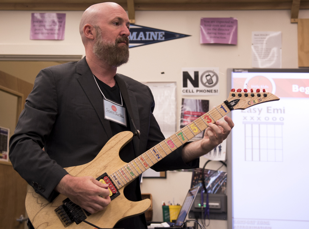 Scott Burstein, director of training and learning with the organization Little Kids Rock, demonstrates chords at a teacher training at Waterville Senior High School on Wednesday.