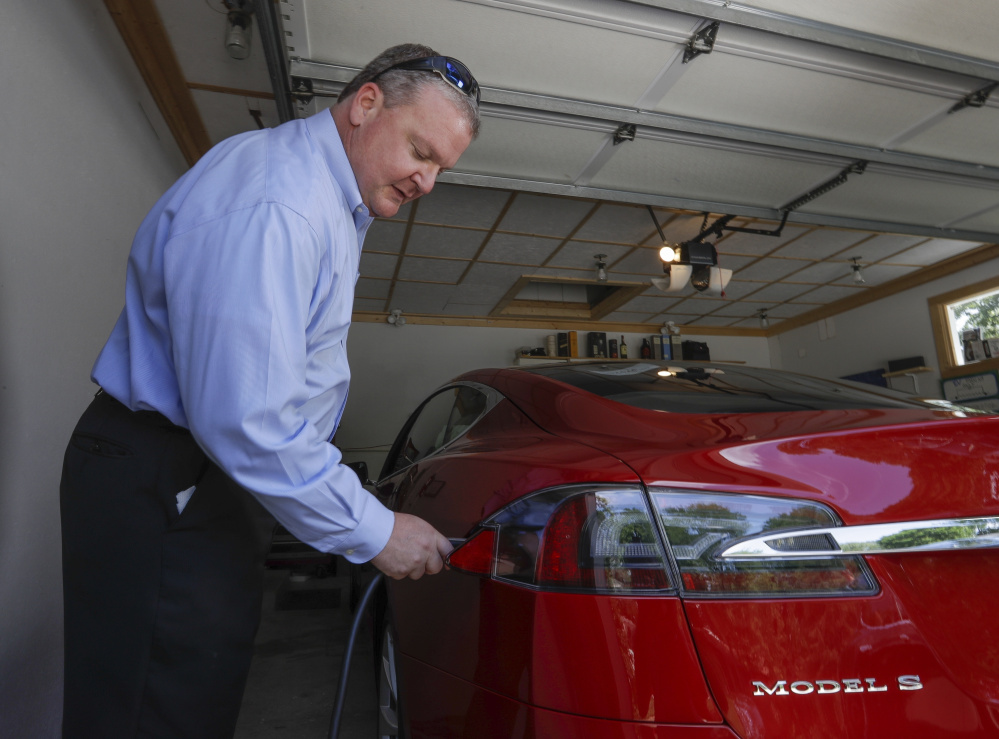 Jeff Solie charges his electric Tesla sedan at his home in New Berlin, Wis., last month. Electric cars are seeing growing support around the world. But there's a problem: There aren't enough places to plug in. Solie says his home system allows him to rely on electric as his primary mode of travel.
