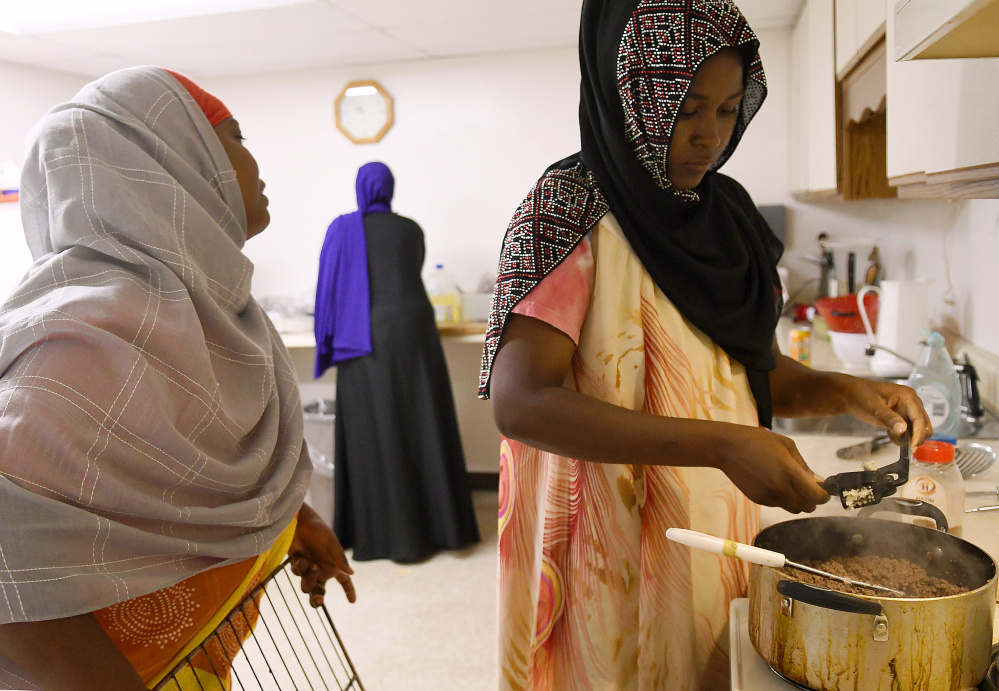 Women prep deep-fried sambusas at the Viles Arboretum kitchen in Augusta for the Beyond Borders Farmers Market. Khadija Hussein, left, Asli Hassan and Farhiya Ibrahim serve the traditional Somali food at the market run by refugees who have resettled in Maine.
