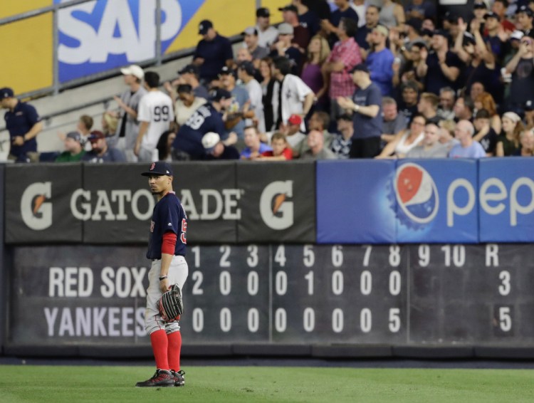 The scoreboard shows the damage as Mookie Betts stands in the outfield in the decisive eighth inning.
