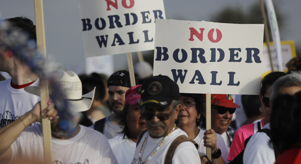 Hundreds of people march along a levee in South Texas toward the Rio Grande to oppose the wall that President Trump wants to build on the river separating Texas and Mexico in Mission, Texas, on Saturday.