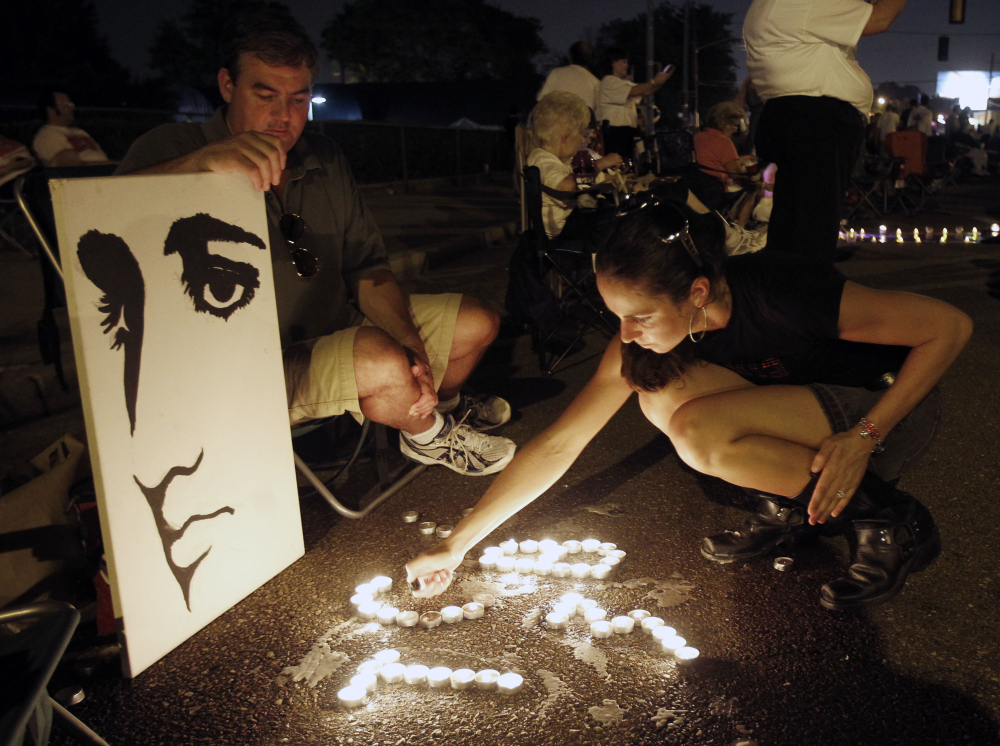Fans light candles at an Elvis Presley display in front of Graceland on Aug. 15, 2010. 