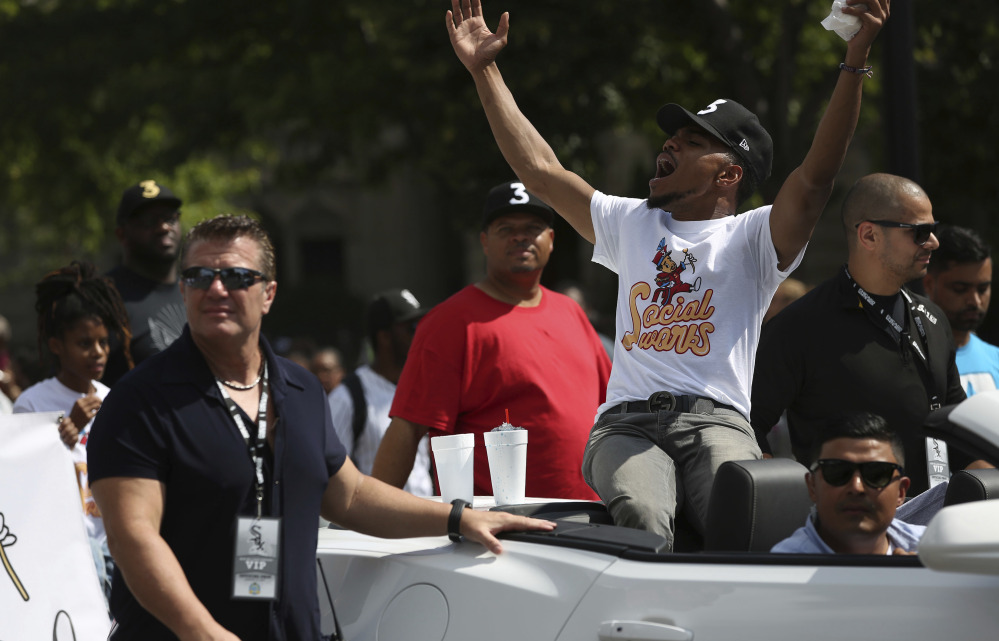 Grammy Award-winning artist Chance the Rapper, center, the grand marshal of the 2017 Bud Billiken Parade, waves at the crowds during Saturday's festivities in Chicago.