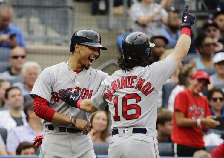 Boston's Mookie Betts, left, celebrates with Andrew Benintendi after Benintendi hit a three-run home run during the third inning Sunday against the Yankees in New York. Benintendi had a pair of three-run homers for the Red Sox.