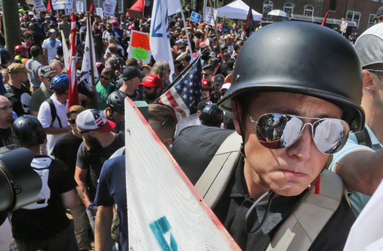 A white nationalist demonstrator with a helmet and shield walks into Lee Park in Charlottesville, Va., Saturday. Hundreds of people chanted, threw punches, hurled water bottles and unleashed chemical sprays on each other after violence erupted at a white nationalist rally in Virginia. At least one person was arrested.