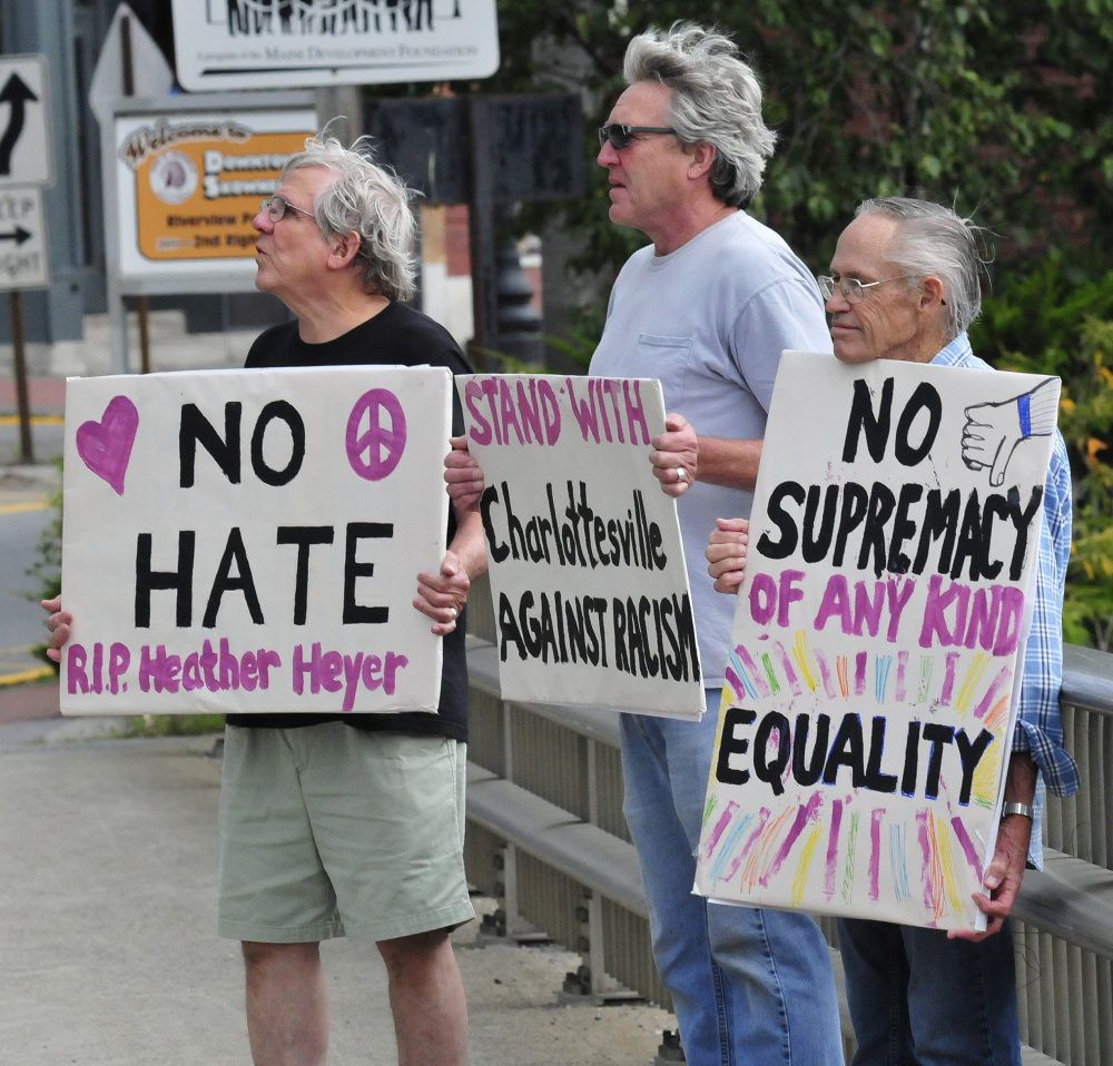 Protesters with Stand With Charlottesville Against White Supremacy hold signs Sunday. From left are Mark Roman, Greg Williams and Dale Riddle.