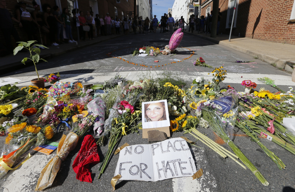 A makeshift memorial of flowers and a photo of victim Heather Heyer sits in Charlottesville, Va., on Sunday. Heyer died when a car rammed into a group of people protesting the presence of white supremacists who had gathered in the city for a rally Saturday.