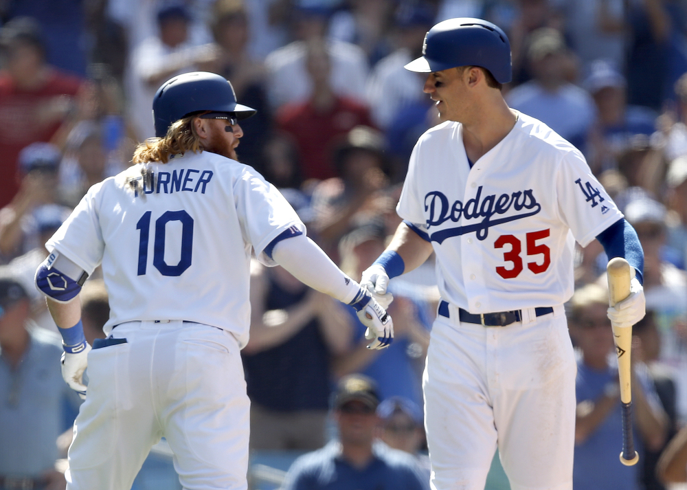 Los Angeles Dodgers' Justin Turner, left, celebrates his solo home run with Cody Bellinger during the eighth inning of a baseball game against the San Diego Padres in Los Angeles, Sunday, Aug. 13, 2017. (AP Photo/Alex Gallardo)