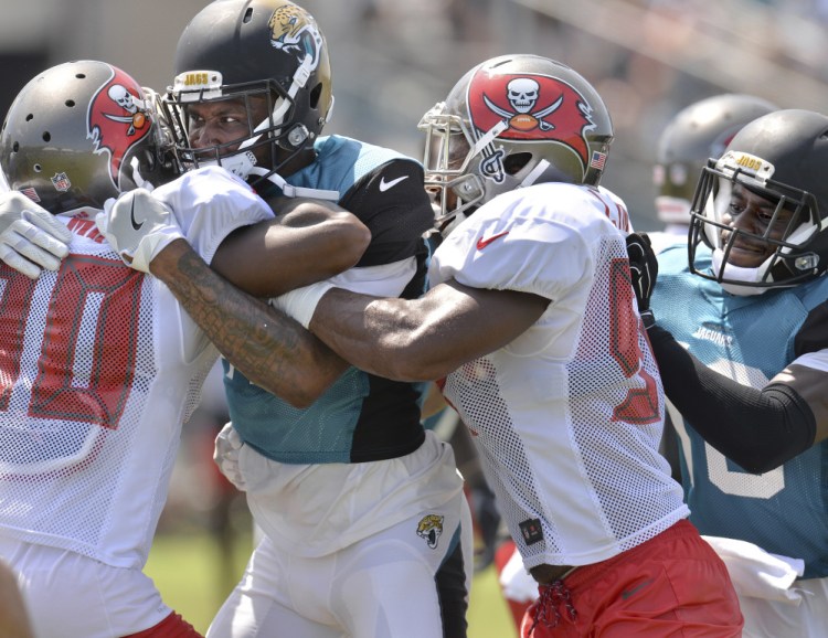 Things weren't entirely rosy Tuesday when the Tampa Bay Buccaneers held a joint practice with the Jacksonville Jaguars. Maurice Fleming of Tampa Bay, left, is grabbed by Jamal Robinson of Jacksonville.