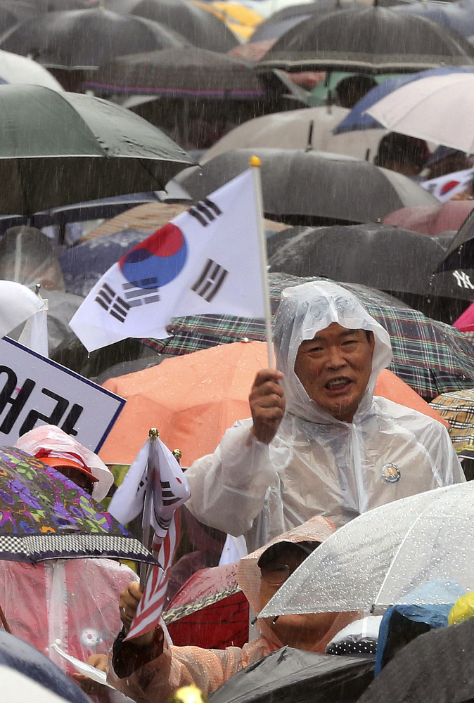 A South Korean waves a national flag during a Tuesday rally against North Korea's missile launches.