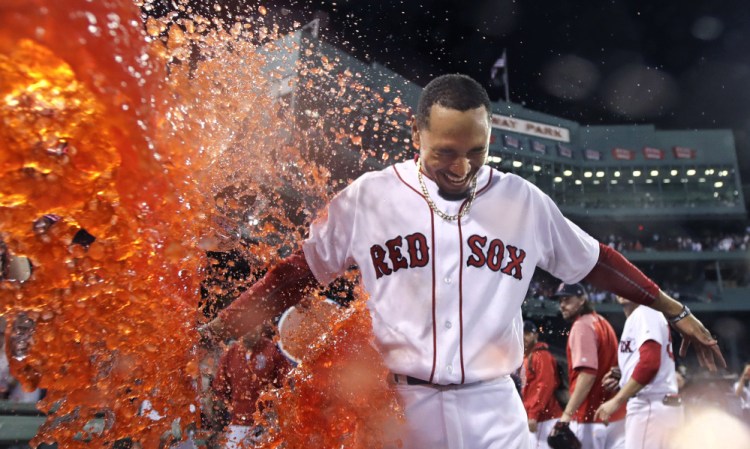Mookie Betts is doused after his walk-off two-run double in the ninth inning Wednesday night against the St. Louis Cardinals at Fenway Park. Betts' two-out double gave Boston a 5-4 win.