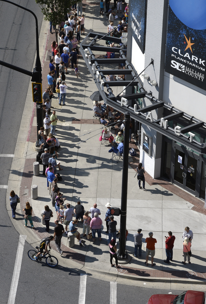 Hopeful eclipse-watchers line up outside the Clark Planetarium in Salt Lake City to get eclipse glasses from the gift shop Thursday. Eclipse mania is building and so is demand for the glasses that make it safe to view the first total solar eclipse to cross the U.S. in 99 years.
