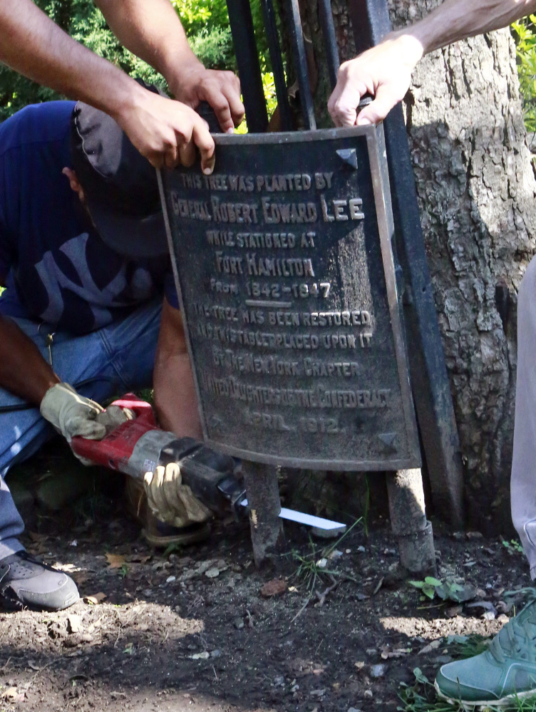 Workers remove two plaques honoring Gen. Robert E. Lee from the property of St. John's Episcopal Church in Brooklyn, New York, in the wake of last weekend's deadly white nationalist rally in Charlottesville, Virginia.