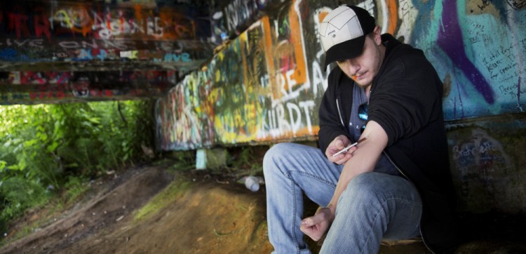 Forrest Wood, 24, injects heroin into his arm under a bridge along the Wishkah River at Kurt Cobain Memorial Park in Aberdeen. Wood grew up here, watching drugs take hold of his relatives, and he swore to himself that he would get out. But he started taking opioid painkillers as a teenager, and before he knew it he was shooting heroin.