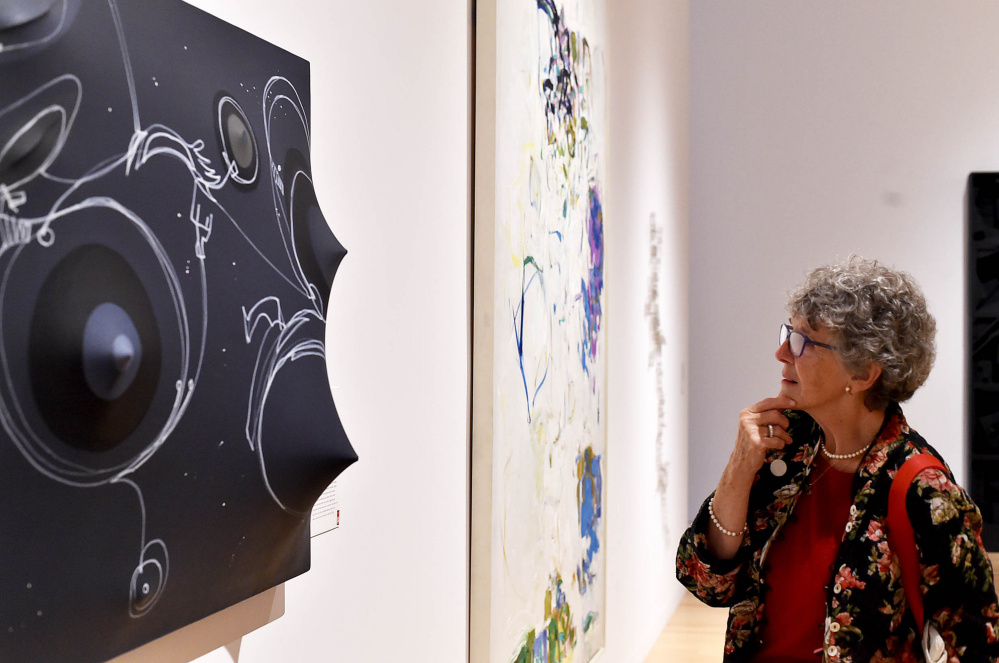 Suzanne Rankin inspects a piece of artwork at the Colby College Museum of Art. A member of the Colby family, Rankin came to Saturday's reunion from Wisconsin.